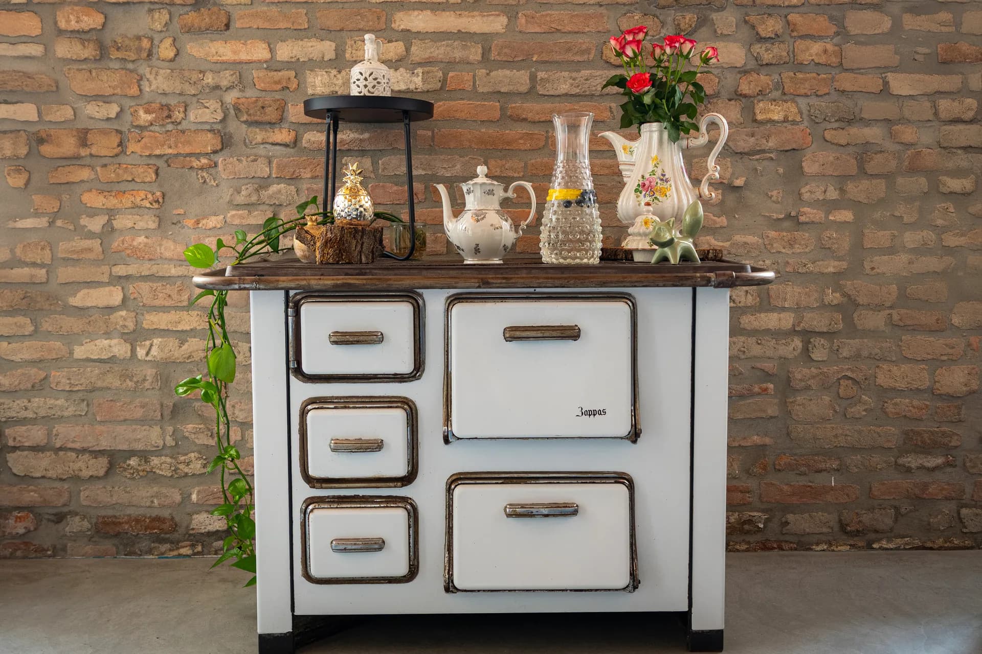 Cucina vintage con stufa d'epoca, teiera fiorata e rose rosse — il cuore del B&B