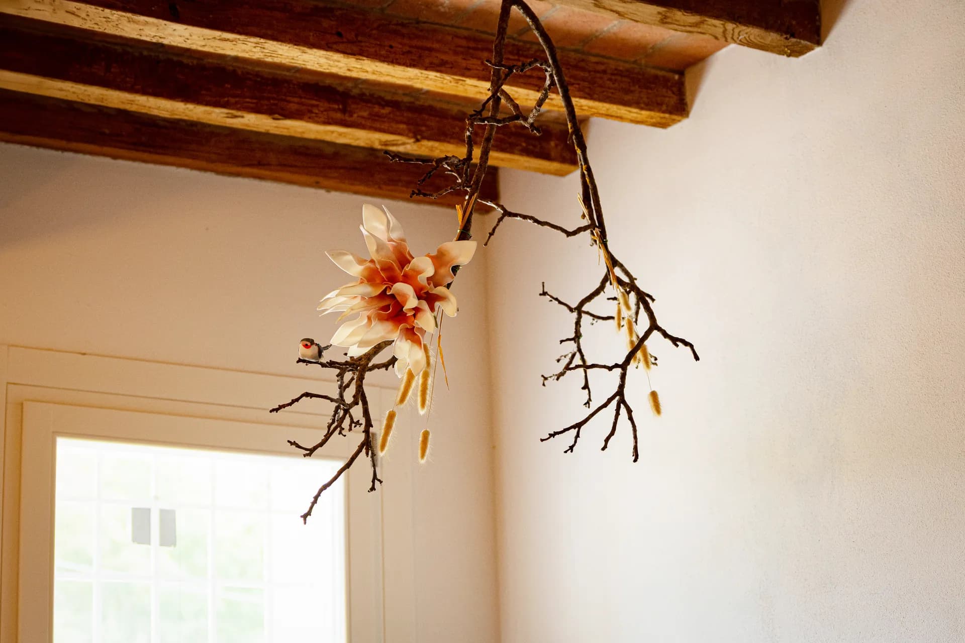 Decorazione a ramo con fiore e uccellino tra le travi in legno